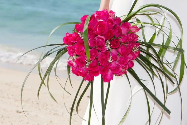 Sposa tenendo bouquet da sposa sul mare e sfondo spiaggia — Foto Stock