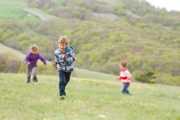 Tres niños felices jóvenes que se divierten en el fondo natural —  Fotos de Stock