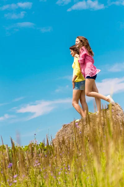 Deux jeunes femmes heureuses sur fond naturel — Photo