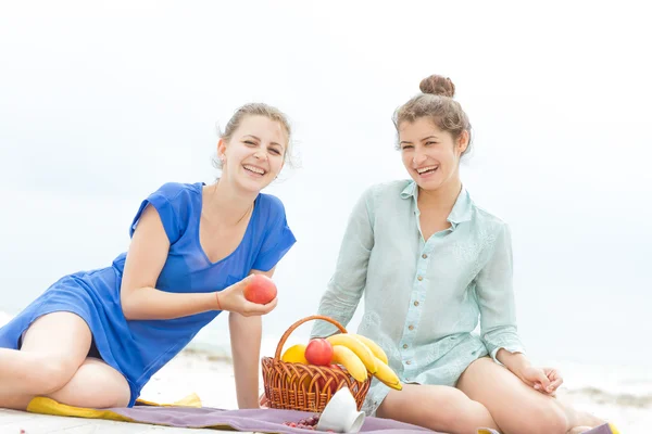 Dos mujeres felices jóvenes disfrutando de la vida durante el picnic al aire libre con f — Foto de Stock