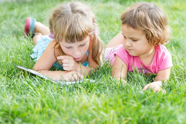 Κορίτσι μικρό παιδί ανάγνωση βιβλίου σε εξωτερικούς χώρους, σε φυσικές φόντο — Φωτογραφία Αρχείου