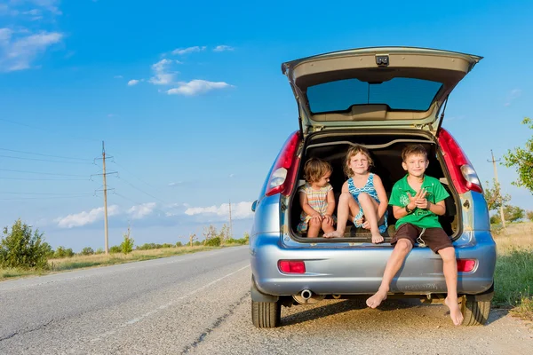 Tres niños felices en coche, viaje en familia, viajes de vacaciones de verano —  Fotos de Stock