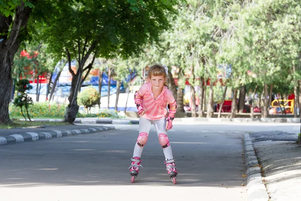 Bonito feliz criança menina patinação no fundo natural — Fotografia de Stock