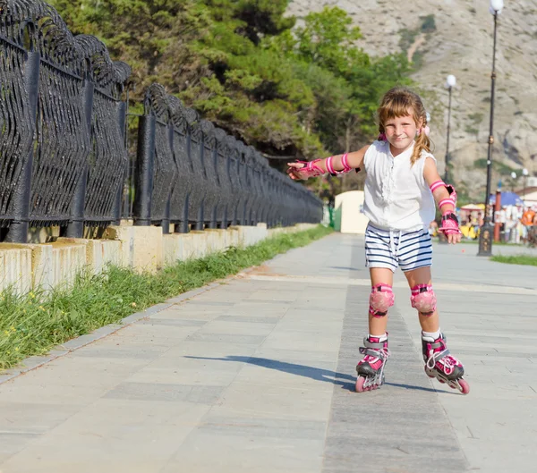 Niedlich glücklich Kind Mädchen Rollschuhlaufen auf natürlichem Hintergrund — Stockfoto