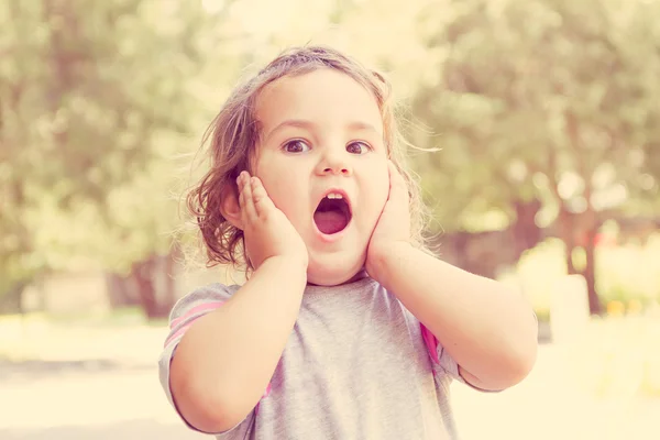 Outdoor Portret van verrast schattig kind meisje op natuurlijke backgro — Stockfoto