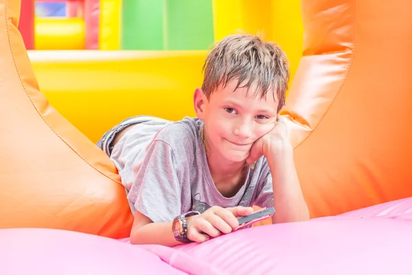 Jovem menino feliz se divertindo no playground — Fotografia de Stock