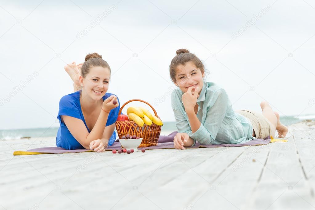 two young happy women enjoying life during outdoor picnic with f