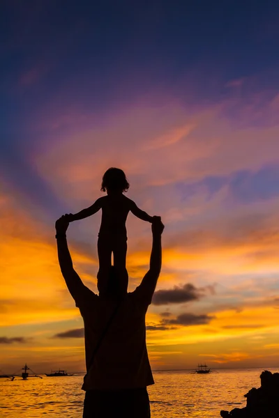 Baba ve çocuk günbatımı deniz arka plan üzerinde siluetleri — Stok fotoğraf