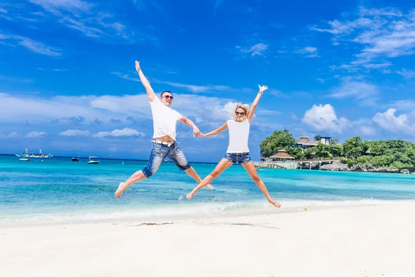 Молодая любящая пара отдыхает на песке тропический пляж на голубом небе — стоковое фото