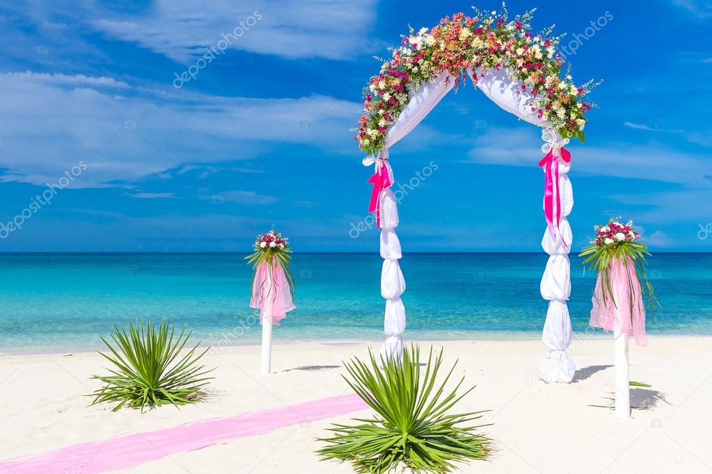 wedding arch, cabana, gazebo on tropical beach decorated with fl