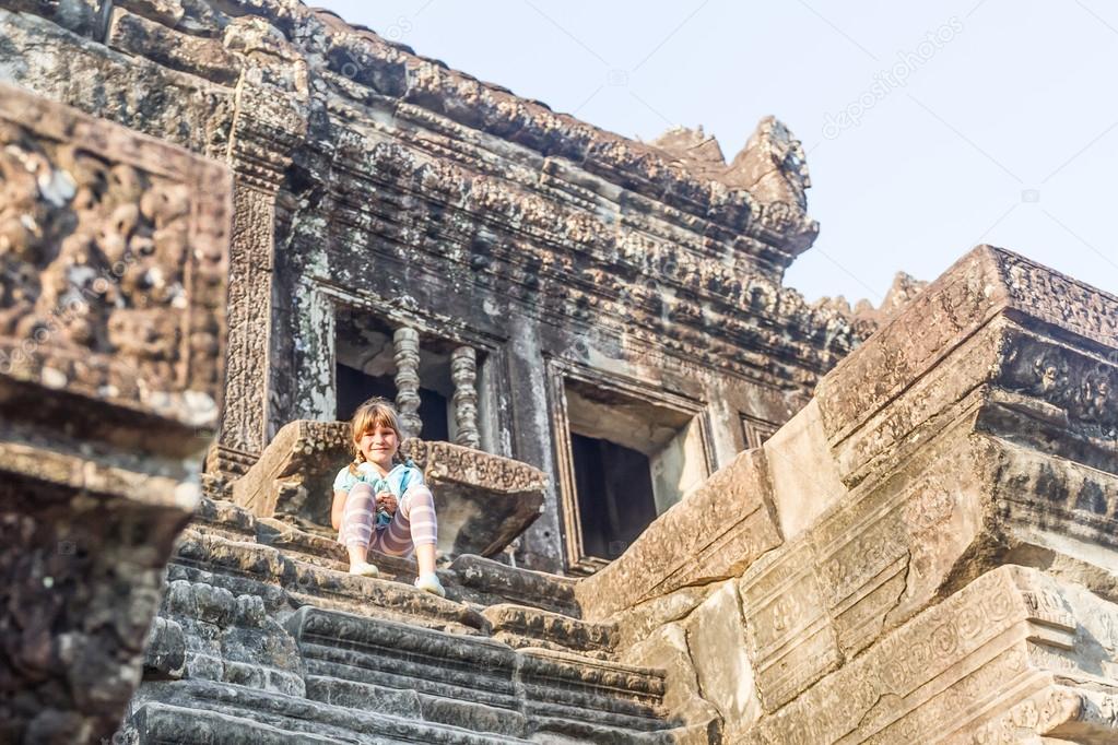 young happy child girl tourist in angkor wat, cambodia