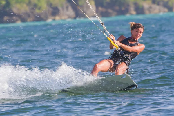 Uma jovem kite-surfista cavalga em mar azul — Fotografia de Stock