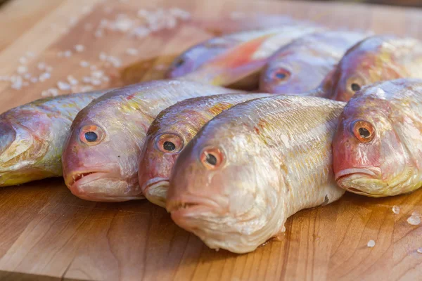 Peixe fresco em tábua de corte de madeira pronto para cozinhar — Fotografia de Stock