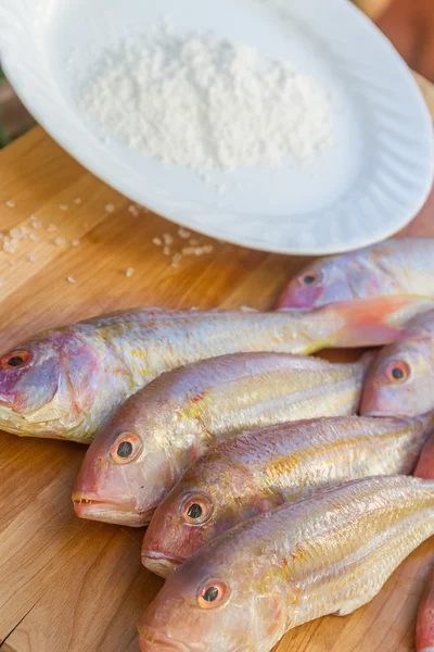 Pesce fresco su tagliere di legno pronto per la cottura — Foto Stock