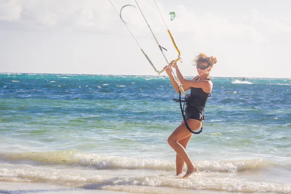 Mladá žena kite surfař se připravovat pro kiting na písku tropica — Stock fotografie