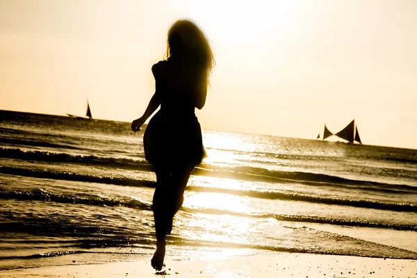 Silhouet van jonge vrouw op zonsondergang zee achtergrond — Stockfoto