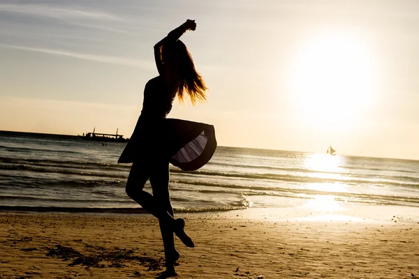 Silueta mladé ženy, na pozadí moře při západu slunce — Stock fotografie
