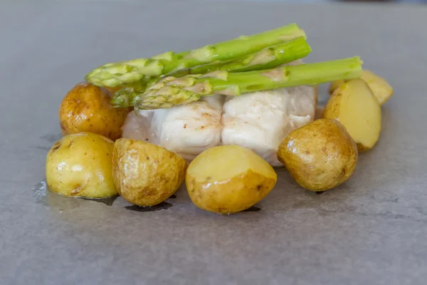 Lichtjes gebakken vis segmenten met asperges en aardappel klaar voor c — Stockfoto