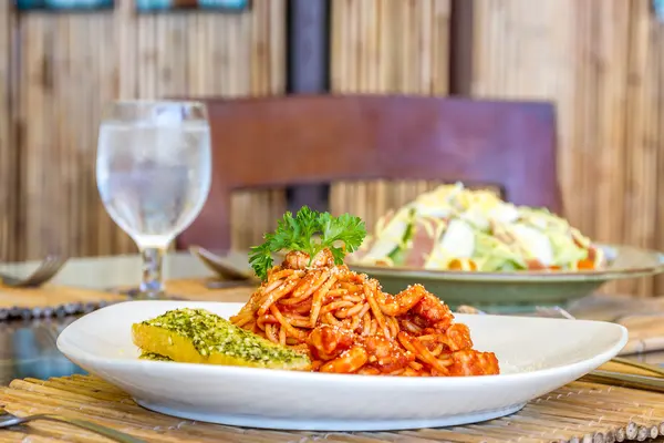 Seafood pasta in tomato sauce served in a small outdoor restaura — Stock Photo, Image