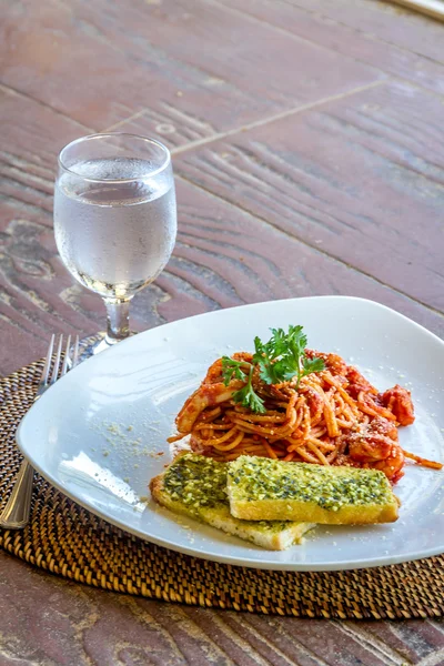 Zeevruchten pasta in tomatensaus geserveerd in een klein buiten restauran — Stockfoto