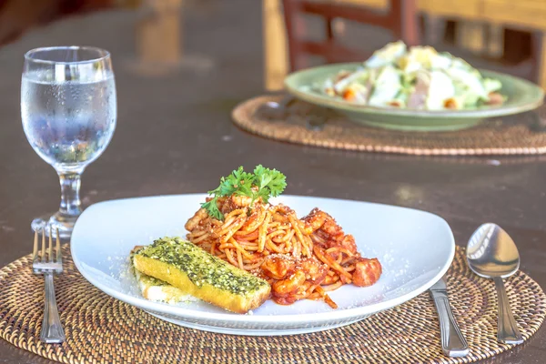 Zeevruchten pasta in tomatensaus geserveerd in een klein buiten restauran — Stockfoto