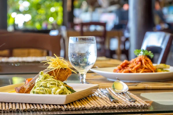 Grilled salmon steak served with pasta and vegetables in a small — Stock Photo, Image