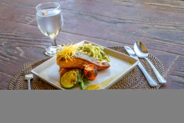 Grilled salmon steak served with pasta and vegetables in a small — Stock Photo, Image