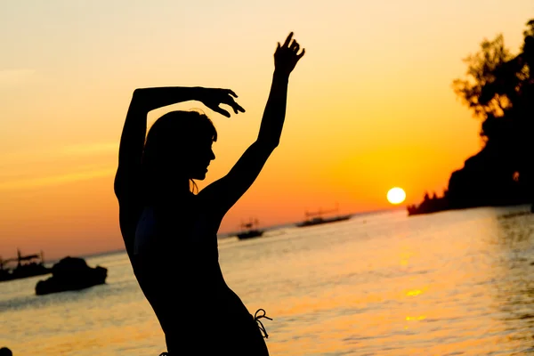 Silhouette of young beautiful woman on tropical sunset sea backg — Stock Photo, Image