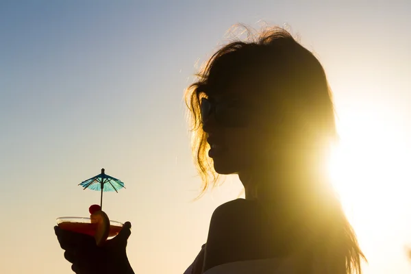 Silhouette einer jungen glücklichen Frau, die den Sommerurlaub am Strand genießt — Stockfoto