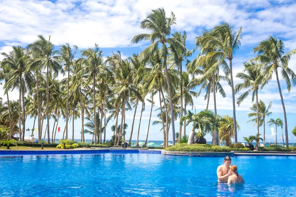 Giovane coppia amorevole rilassante in piscina, resort tropicale, va d'estate — Foto Stock