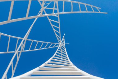 Beyaz merdivenler üzerinde mavi gökyüzü izole labirent