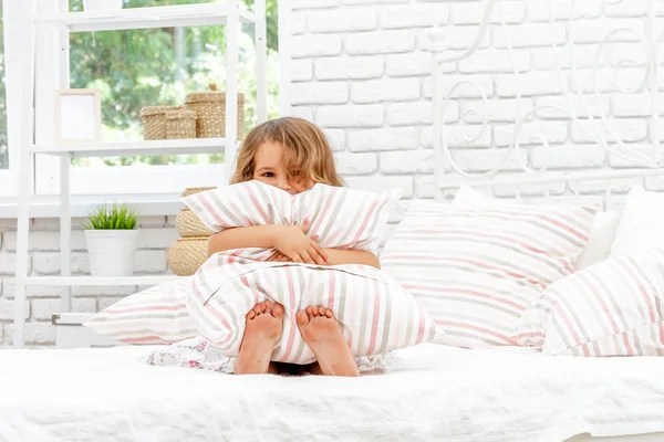 Jeune fille heureuse enfant au lit à la maison, portrait intérieur — Photo