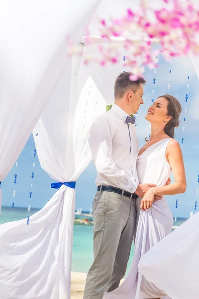Braut und Bräutigam am Hochzeitstag am natürlichen tropischen Strand — Stockfoto