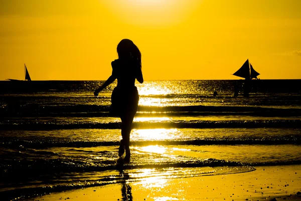 Unbekümmerte Frau tanzt im Sonnenuntergang am Strand. Urlaubsvita — Stockfoto