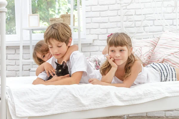 Троє дітей, діти, хлопчик і дівчатка, граються з чорним маленьким c — стокове фото