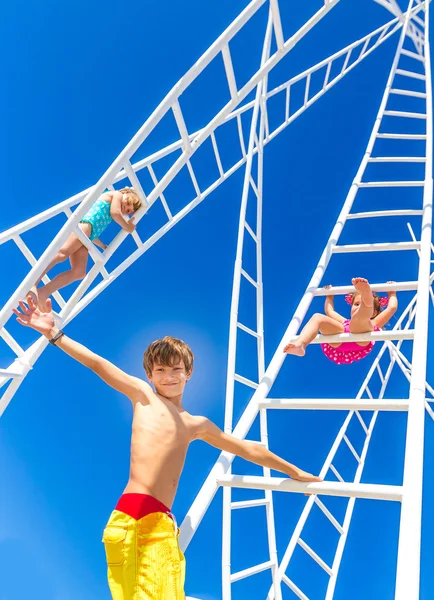 Jonge gelukkige jonge geitjes - jongen en meisje - witte ladders n gaan klimmen — Stockfoto