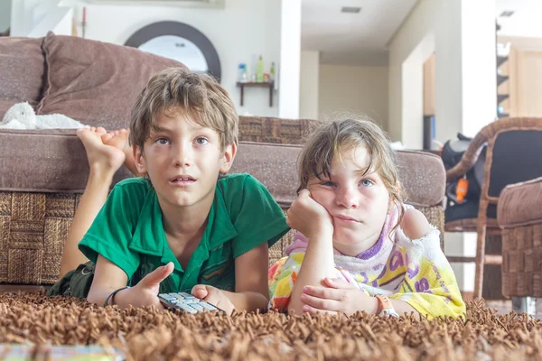 Deux jeunes enfants regardant la télévision à la maison — Photo