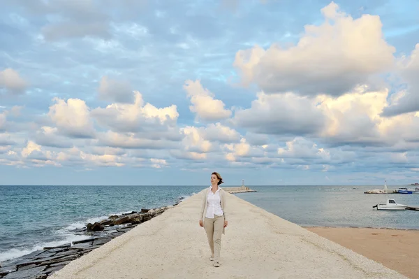 Kvinnan promenader på kajen - konceptuella bild frihet serenity sinnesfrid positiva — Stockfoto