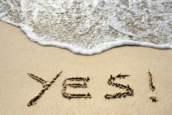 Oui écrit sur la plage de sable près de la mer — Photo