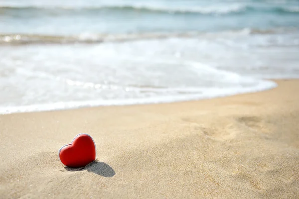Червоне серце на морському пляжі - люблю розслаблятися концепція — стокове фото