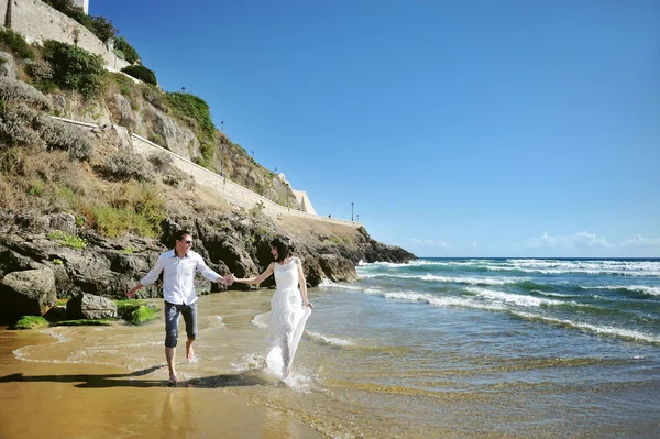 Šťastná usmívající se běží pár u moře, Sperlonga, Itálie — Stock fotografie