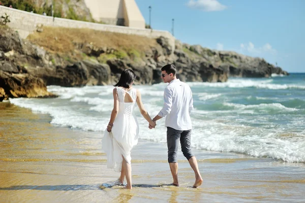 Невеста и жених идут вместе, держа руки у моря, Сперлонга — стоковое фото