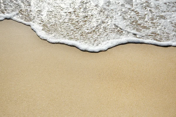 คลื่นทะเลบนชายหาดทราย — ภาพถ่ายสต็อก