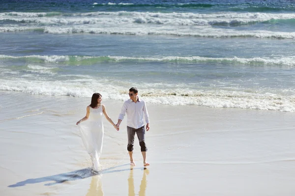 Bride and groom holding hands near sea in wedding day — Stock Photo, Image