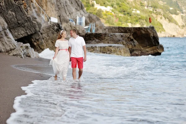 Lyckliga par promenader på stranden Positano i bröllopsdag — Stockfoto