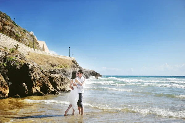 Bruid en bruidegom kussen op het strand in huwelijksdag in Italië — Stockfoto