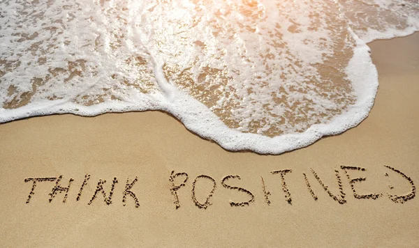 Pensare positivo scritto sulla spiaggia di sabbia - concetto di pensiero positivo — Foto Stock