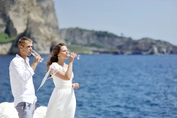 Пара пьет шампанское в день свадьбы у моря Неаполя, Италия — стоковое фото