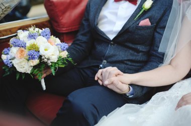 Gelin ve damat el ele tutuşuyorlar.