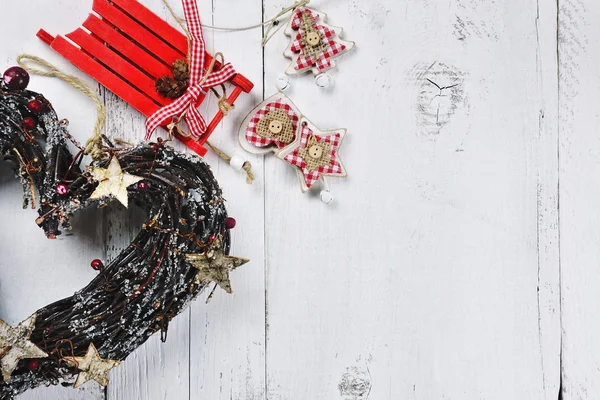 De kroon van Kerstmis en rode slee op houten achtergrond — Stockfoto